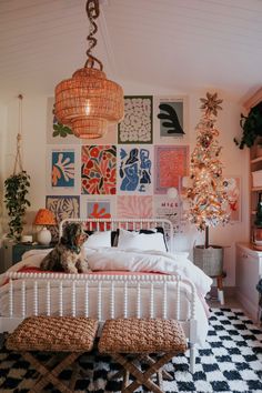 a cat sitting on top of a bed in a room with pictures on the wall