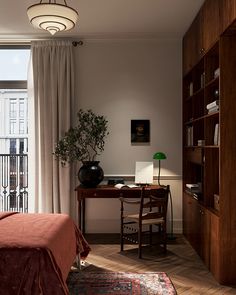 a bedroom with a bed, desk and bookshelf in front of a window