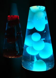 two vases with blue and red lights in the dark, one is lit up