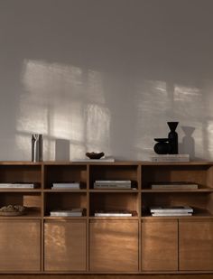 a wooden shelf with books and vases on it