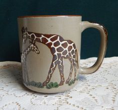 a giraffe mug sitting on top of a white tablecloth covered table cloth