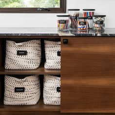 some baskets are sitting on top of a wooden cabinet