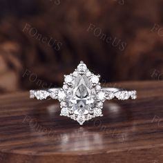 an oval cut diamond engagement ring on top of a wooden table