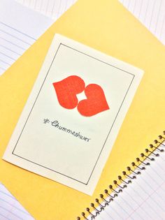 a notepad with two paper hearts on it