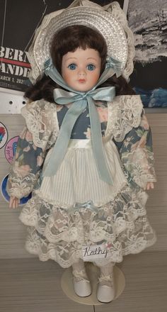 the doll is wearing a dress and hat