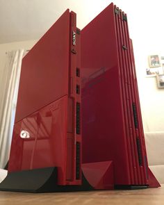 a red computer sitting on top of a wooden table