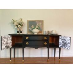 two black and gold sideboards with vases on top