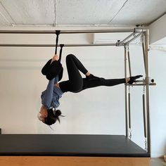 a woman doing aerial acrobatics on a black mat