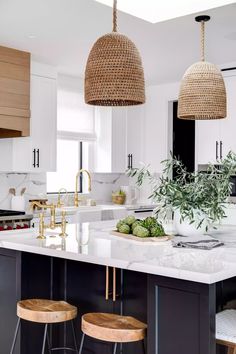 a kitchen with two stools next to an island and some plants on the counter