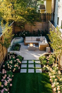 a small backyard with grass and flowers on the ground