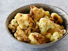 a bowl filled with cooked cauliflower sitting on top of a white countertop