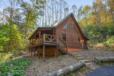 a log cabin in the woods with stairs leading up to it's second floor