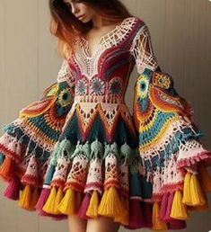 a woman wearing a colorful dress with crochet and tassels on it