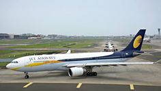 a jet airways plane is parked on the tarmac at an airport with other planes in the background