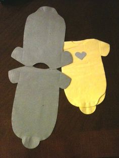 two baby mittens made out of paper on a table