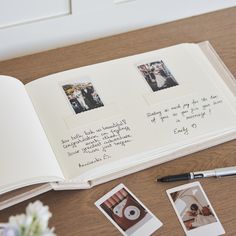 an open book with photos on it next to a pen and some other things that are sitting on the table