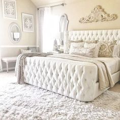 a white bed sitting inside of a bedroom on top of a fluffy carpeted floor