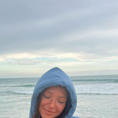 a woman in a blue hoodie holding a cell phone