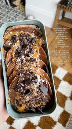 a person holding a container filled with chocolate covered bread