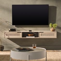 a living room with a large flat screen tv mounted on the wall next to a coffee table