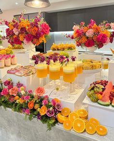 an assortment of fruit and flowers on display at a wedding or brunch buffet