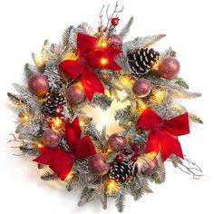 a christmas wreath with red bows and pine cones on white background, decorated with lights