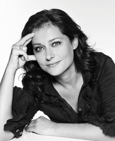 a black and white photo of a woman with her hand on her head, posing for the camera