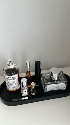 an assortment of perfumes on a black tray