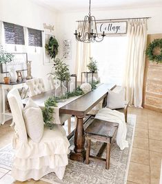 the dining room is decorated with greenery and white furniture