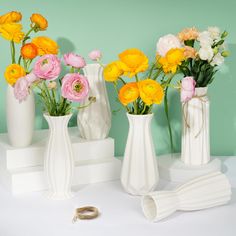 three white vases with yellow and pink flowers in them