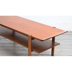 a wooden table sitting on top of a hard wood floor next to a white wall