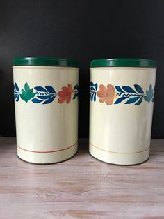 two canisters with flowers painted on them