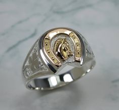 "A nice Horseshoe Ring made in 925 Silver, with a 14k gold horse head. Gold Horseshoe traditionally known for being a symbol of good luck, good luck ring that is also a good complement to the cowboy or cowgirl. A very handcrafted precision work. In addition the ring has a Four Leaf Clover on both sides. This ring looks good on both men and women. Welcome to custom orders. Just let me know how you want this ring and in which of these materials: (silver with gold, yellow gold, rose gold). Custom orders usually take up to 12 business days to make before shipment. RING SIZE The ring is made to your personal size, just select a size that fits your finger. As it is a very careful work, please allow me a reasonable time to prepare your ring and make it to your entire satisfaction. I will send you Mens Jewelry Horseshoe Nas, Elvis Presley Horseshoe Ring, Horse Shoe Ring Mens, Horseshoe Ring Zales, Mens Pinky Ring, Horseshoe Ring, September Birthstone Rings, Ring Man, Handmade Jewelry Ring