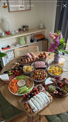 a wooden table topped with lots of different types of food on plates and trays