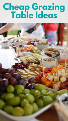 a table with grapes, cheese and crackers on it that says cheap grazing table ideas