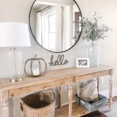 a wooden table topped with a mirror next to a lamp