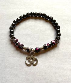 Ohm bracelet with black paint splash beads with black hematite beads. Materials Pink, silver and black paint splash beads Black hematite beads Ohm pendant Postage All items will be sent first class. The estimated delivery will be between 1- 3 days (UK) and out side the UK it will be 7 -14 days depending on where they are being sent. All items will be shipped in a bubble wrap and an envelope. Gift boxes are available, just message me. Custom Items. I am happy to make something to meet your reques Ohm Jewelry, Ohm Bracelet, Cristal Bracelet, Ohm Pendant, Om Bracelet, Envelope Gift, Meditation Bracelet, Om Symbol, Yoga Bracelet