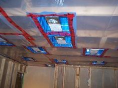 an unfinished room with some red and blue duct tape on the ceiling