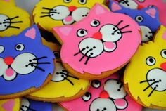 colorful decorated cookies with cats on them are displayed in a pile, ready to be eaten