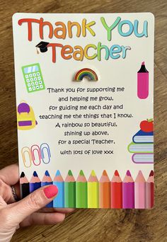 a person holding up a thank you teacher card