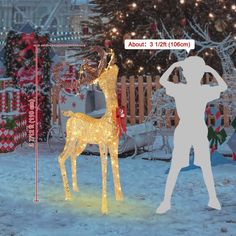 a man standing next to a lighted deer in the snow