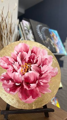 a large pink flower sitting on top of a wooden table