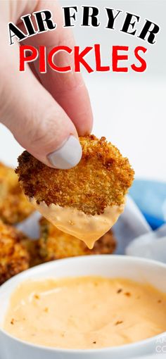 a person dipping some kind of food into a white bowl with sauce in it and the words air fryer pickles above them