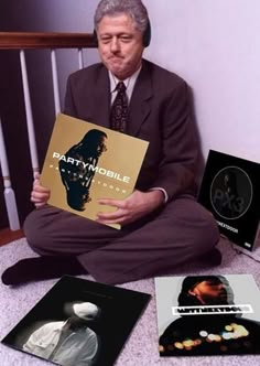 a man sitting on the floor with various records and cd's in front of him