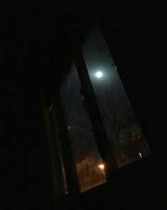 the moon is shining brightly in the dark night sky over an open window with no curtains