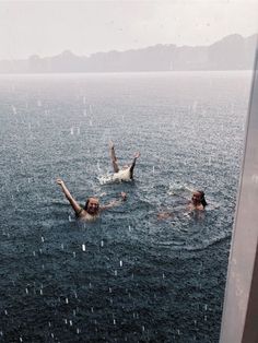 two people are swimming in the water with their arms up and hands out to each other