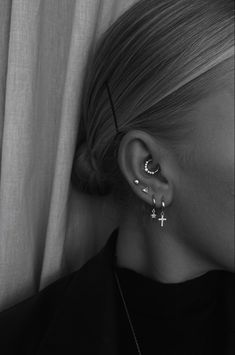 a woman wearing ear piercings with cross on it