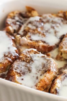 cinnamon rolls with icing in a white casserole dish