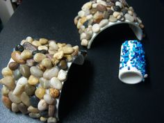 two bracelets made out of rocks sitting on top of a black table next to each other