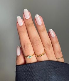 a woman's hand with three different rings on her fingers and one ring in the middle